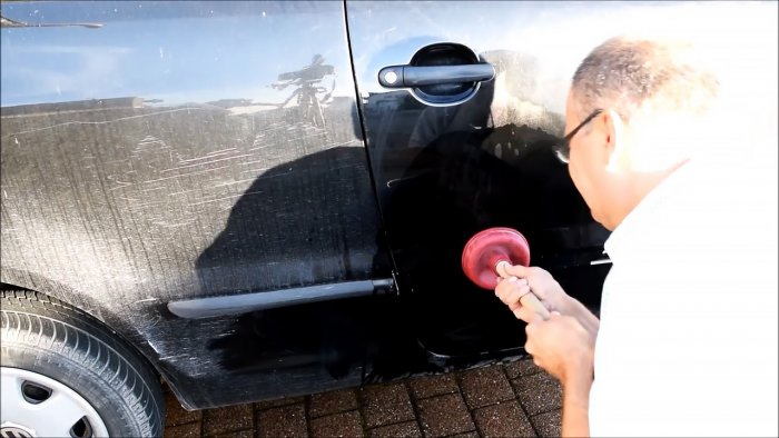 Hur man enkelt fixar en buckla på en bil med hjälp av kokande vatten och en kolv