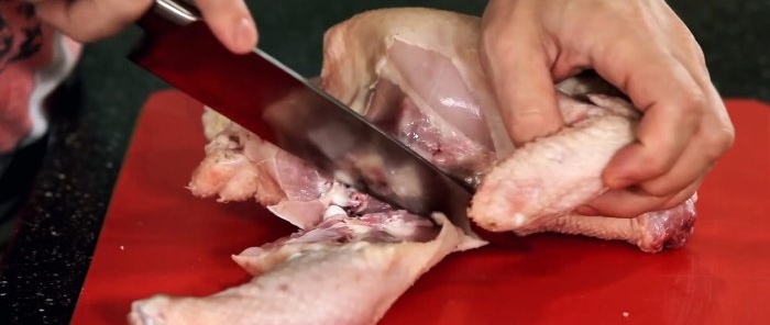 Ein Koch zeigt, wie Hühnchen in den besten Restaurants geschnitten wird
